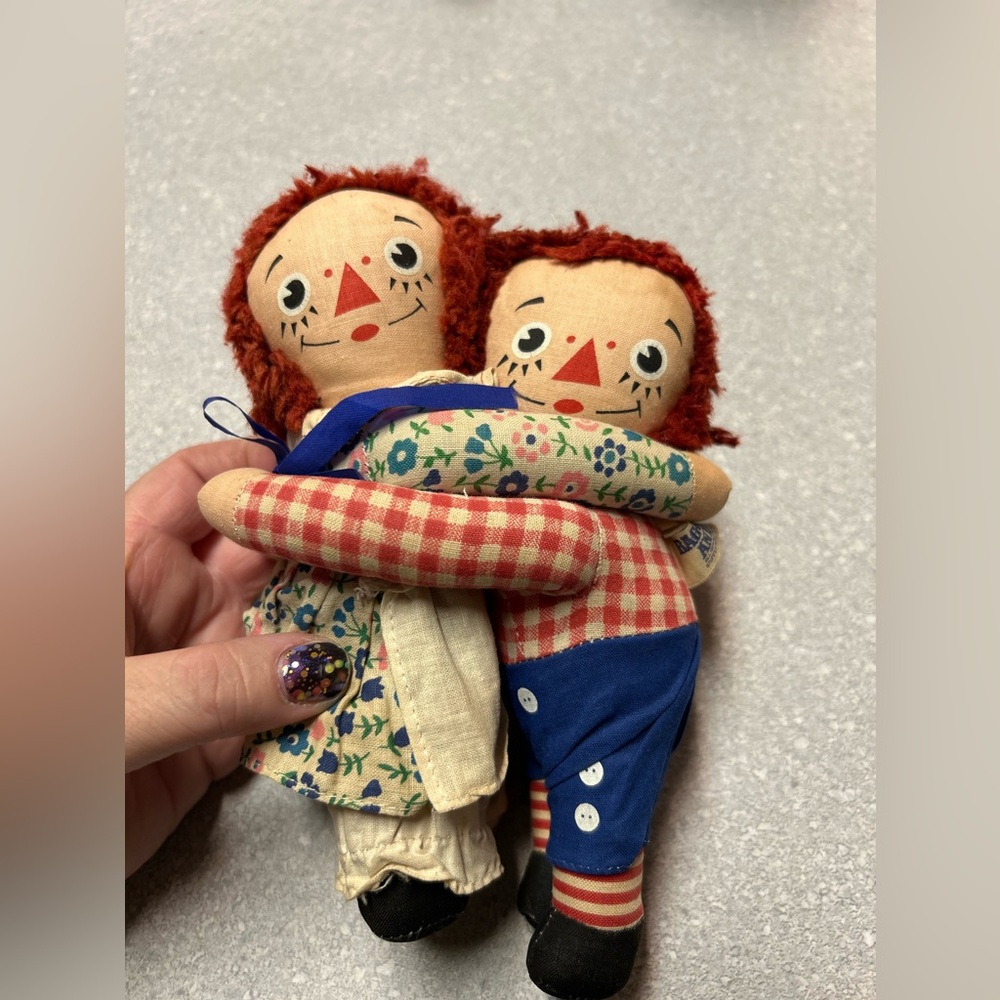 Raggedy Ann hugging vintage dolls